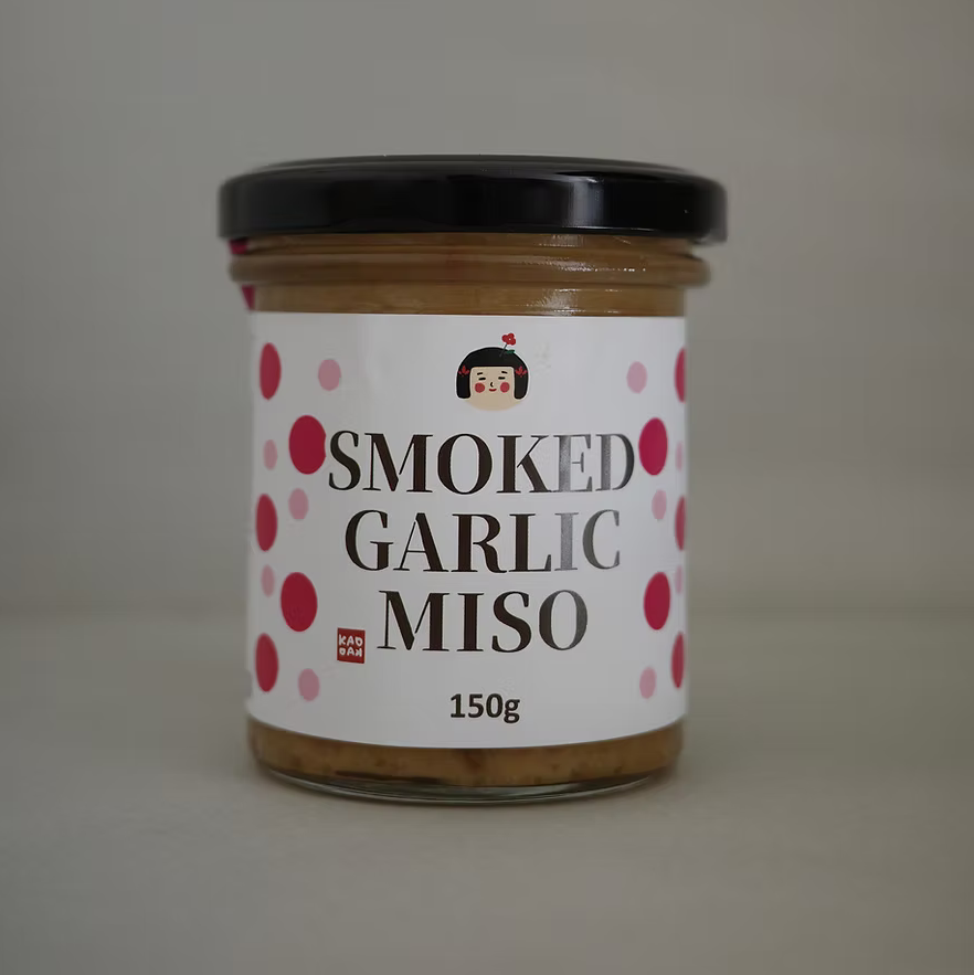 Jar of smoked garlic miso with a label on a plain background