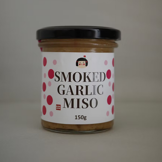 Jar of smoked garlic miso with a label on a plain background